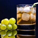 Close-up of a cold drink with green grapes and ice cubes, perfect for a refreshing moment.