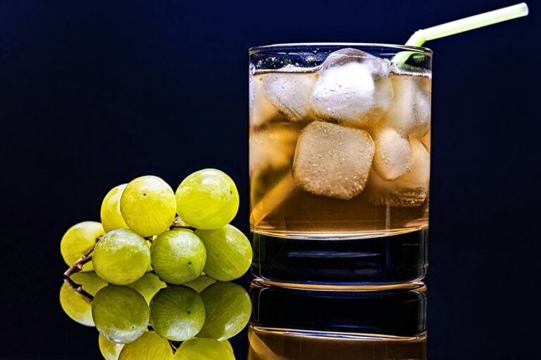 Close-up of a cold drink with green grapes and ice cubes, perfect for a refreshing moment.