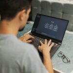 A man working on a laptop displaying ChatGPT's interface in an indoor setting.