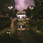 A dynamic cityscape captured through a smartphone, showcasing urban life at dusk.
