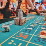 A vibrant view of a casino roulette table with poker chips and players engaged in gambling.