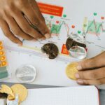 Analyzing financial charts with a calculator and chocolate coins.