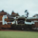 High-resolution image of a DJI Mini 2 drone flying outdoors with a blurred background.