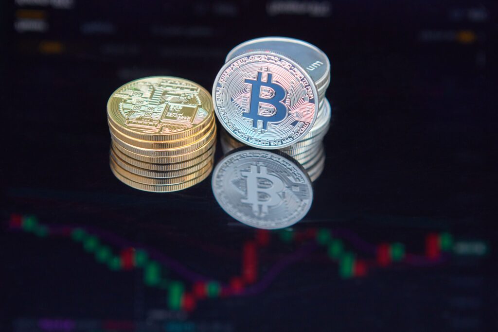 Close-up of bitcoin coins reflecting on a screen with financial market data, highlighting digital currency trend.